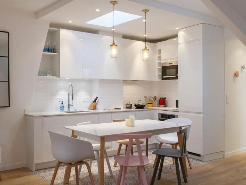 Cuisine Cuisinella blanche avec chaises pastels